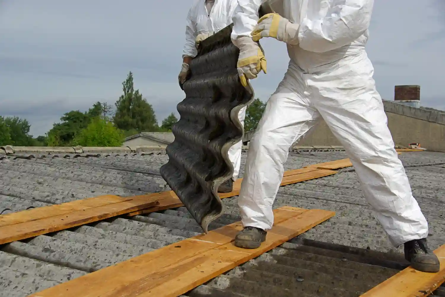 Asbestos removal team in London wearing protective suits and masks