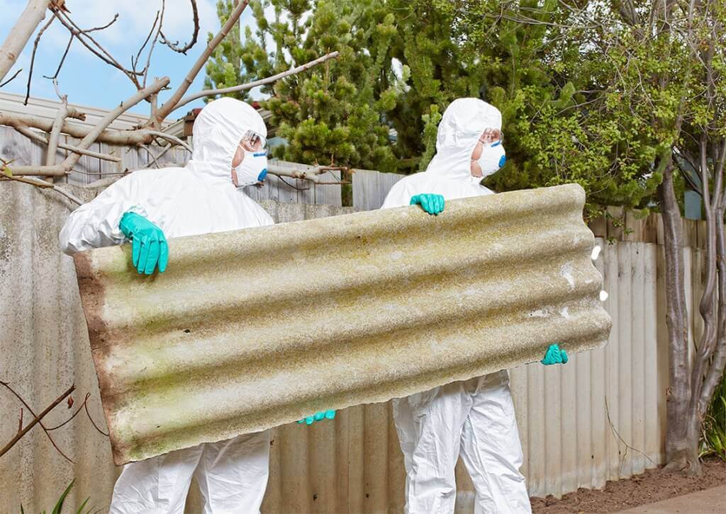 Asbestos insulation and cement material being inspected before removal in London